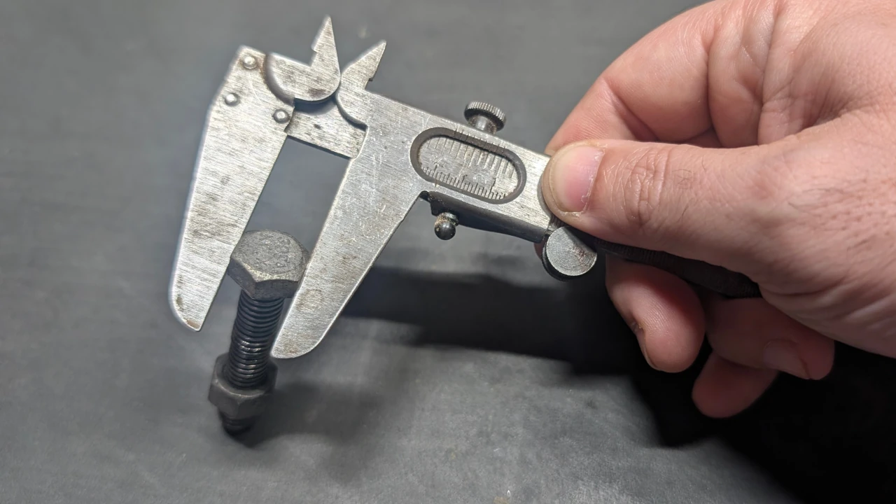 Using a manual caliper to measure bolt size